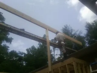 Carpenter setting a ridge beam over a new addition frame — Ice Dam Removal by Roofing Brothers in Scotts Mills