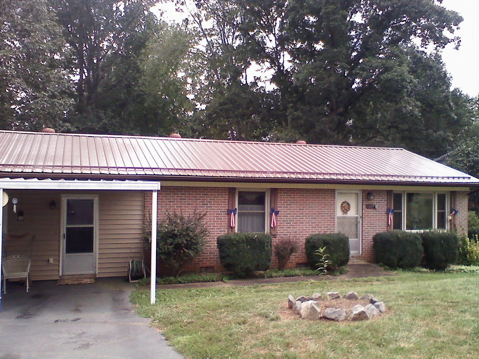 Bronze metal roof and carport on a brick ranch home — Roof Repair work by our crew in Scotts Mills